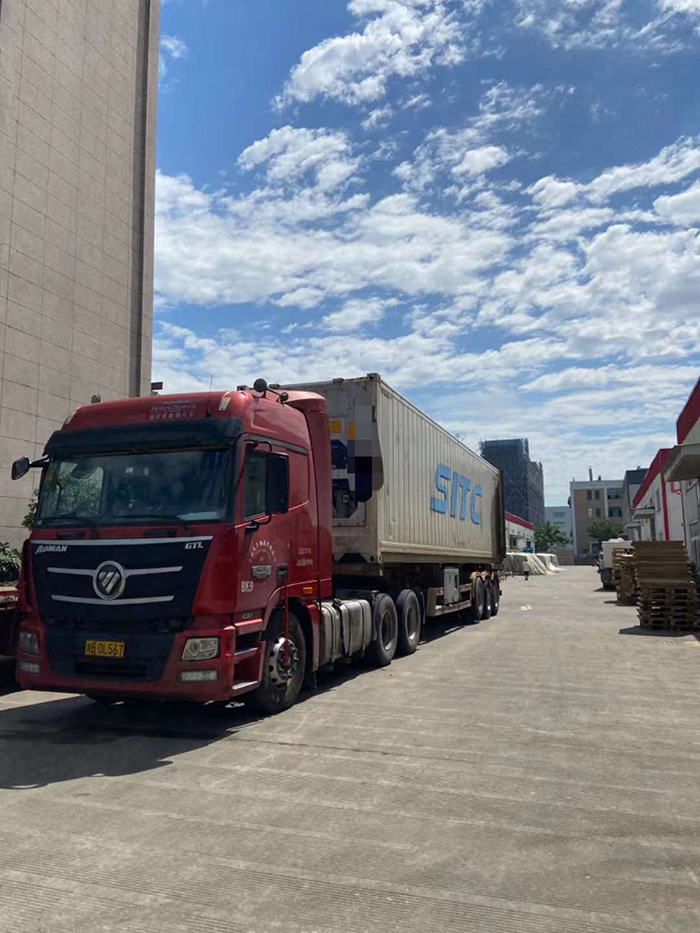 Dedicated Workers Load Two Containers for Export and Two Trucks for Domestic Delivery in Sweltering Heat