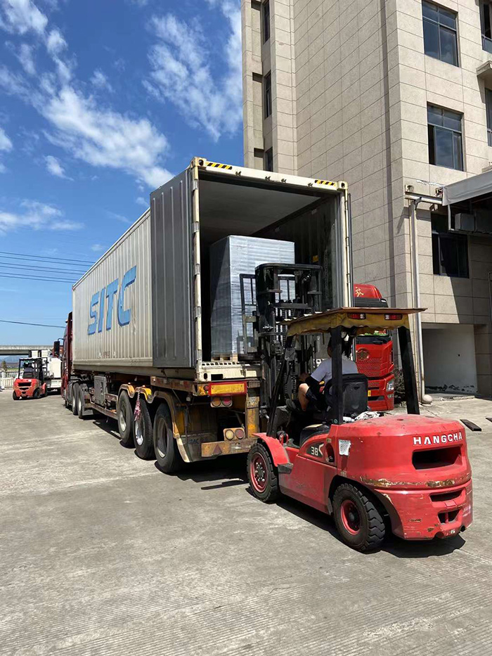 Dedicated Workers Load Two Containers for Export and Two Trucks for Domestic Delivery in Sweltering Heat